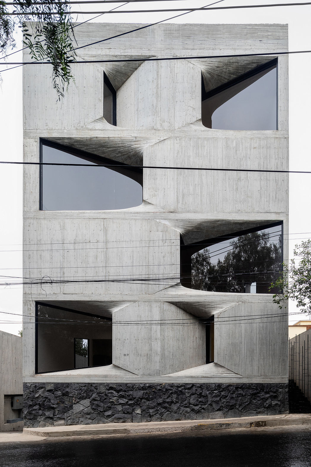 Striking concrete architectural design with geometric patterns and recessed windows.