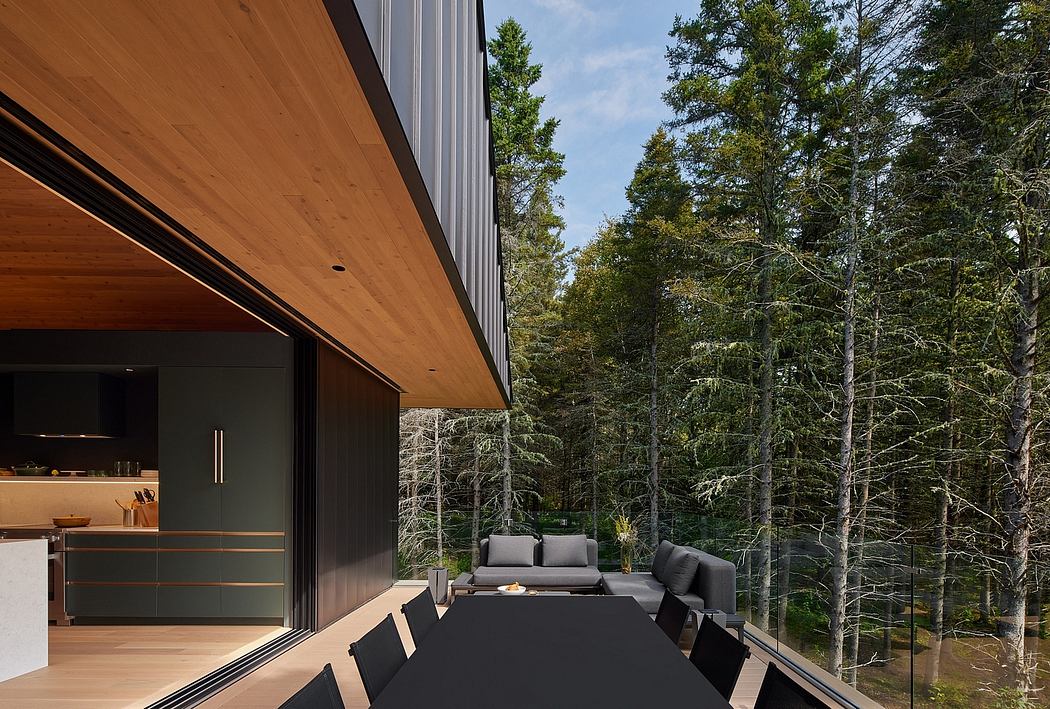 A modern, minimalist cabin with sleek wooden design and large windows overlooking a lush forest.