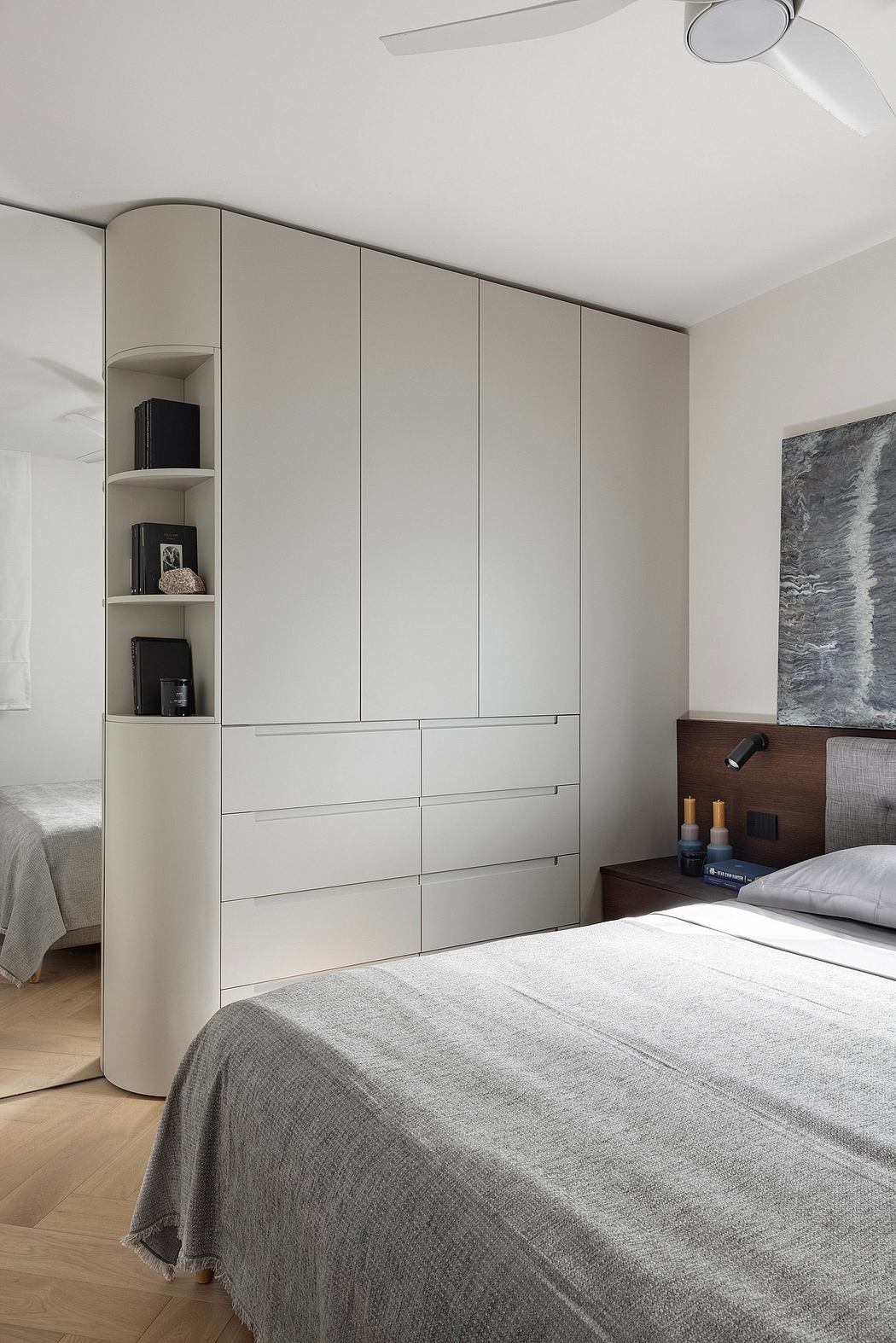 Minimalist bedroom with built-in storage and shelving, muted color palette, and modern lighting.