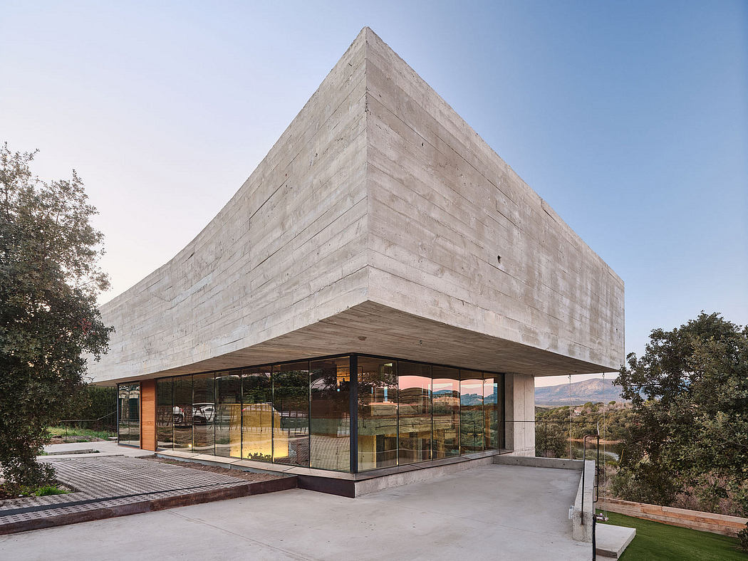 Striking concrete structure with expansive glass walls offering scenic views.
