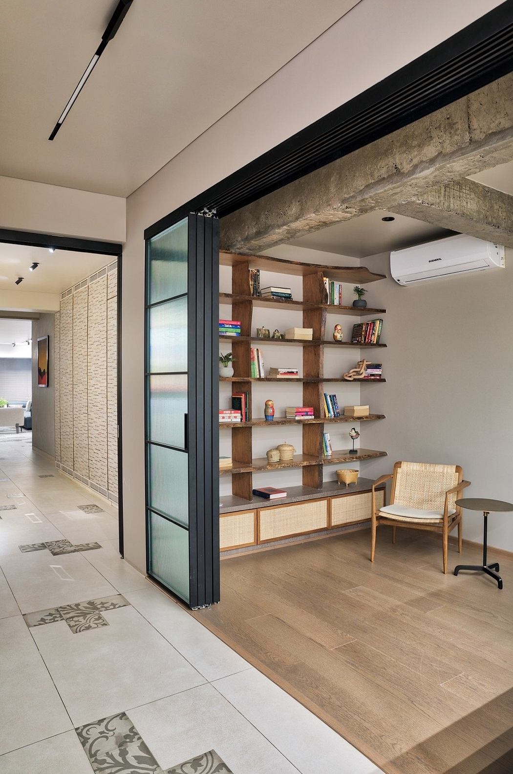 Modern open-concept space with exposed brick, wooden shelves, and a cozy seating area.