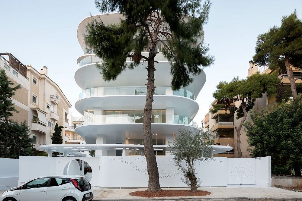 Striking modern apartment building with curved balconies and a towering central structure.