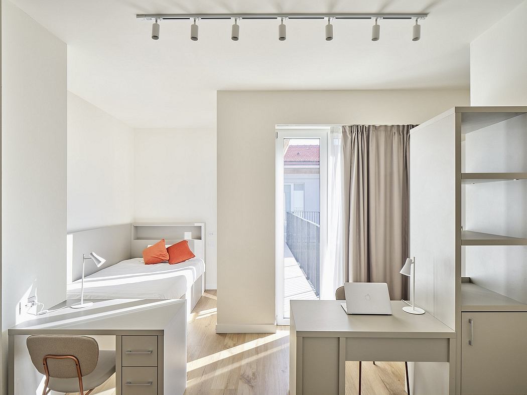 Modern, minimalist bedroom with track lighting, built-in desk, and sliding glass door.