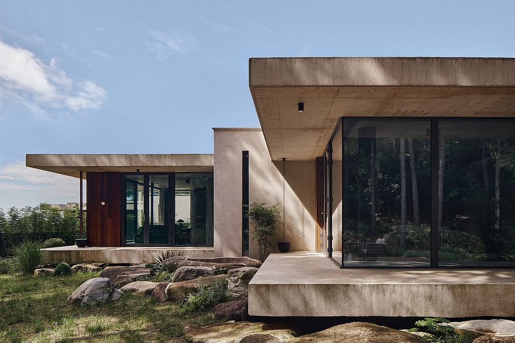 Striking modern architecture with expansive glass windows and concrete canopy overhang.
