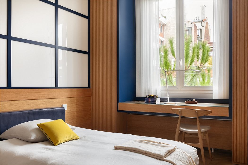 Minimalist bedroom with wood paneling, large window, and desk overlooking greenery.