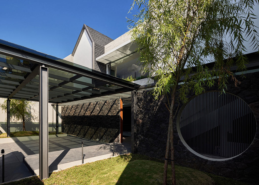 Modern architectural design with steel-framed glass structure, lush greenery, and circular motif.