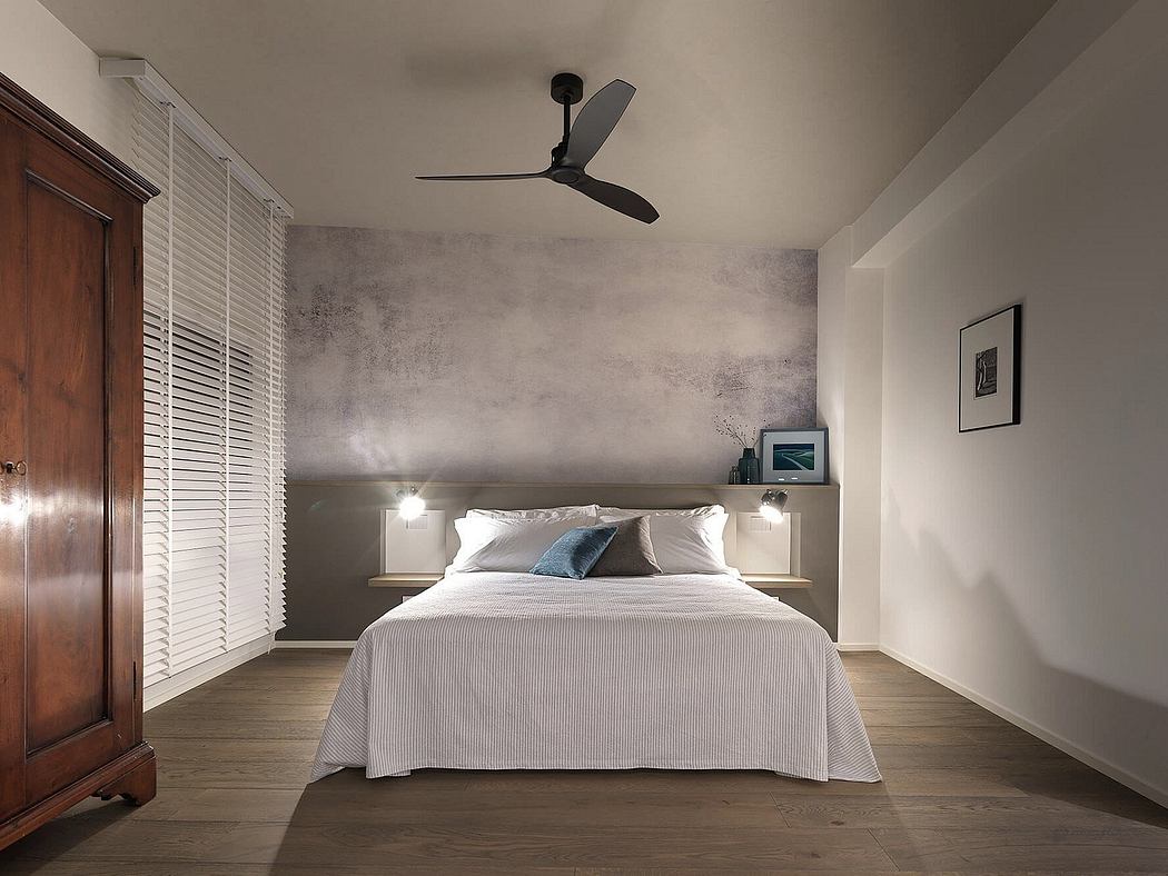 Minimalist bedroom with concrete walls, dark wood furniture, and modern ceiling fan.