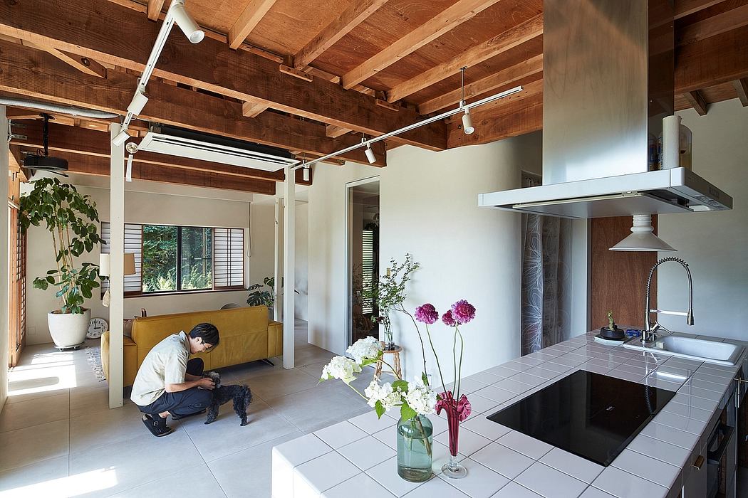 A spacious, open-concept living room and kitchen with exposed wooden beams and modern decor.