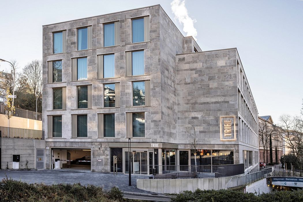 Imposing stone building with prominent windows, metal detailing, and an expansive entryway.