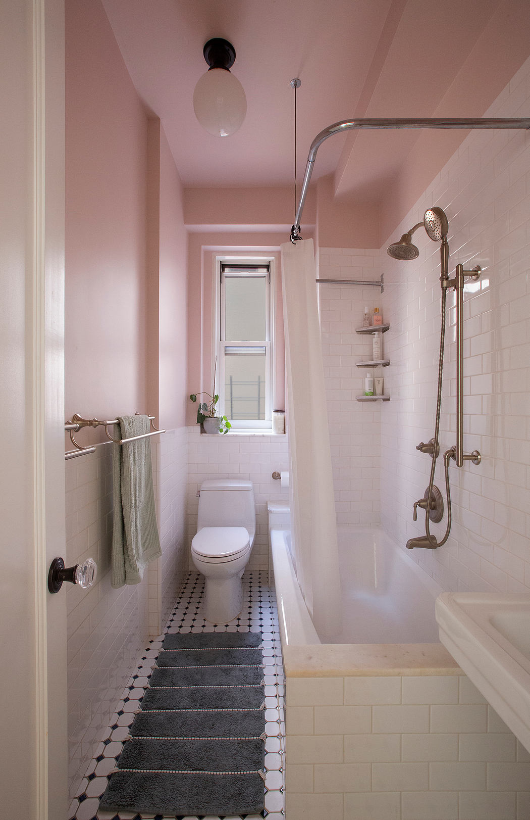 A cozy, pastel-toned bathroom with a shower, vanity, and intricate tiled floor.