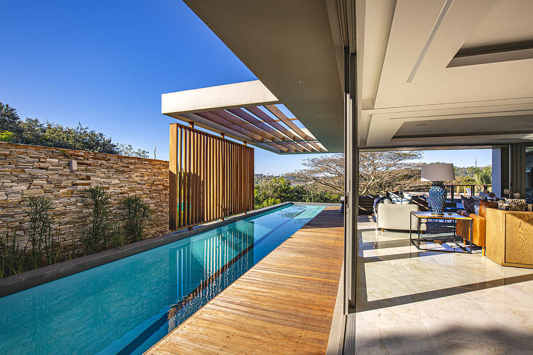 Stunning modern home with sleek pool, wooden deck, and warm, inviting interiors.