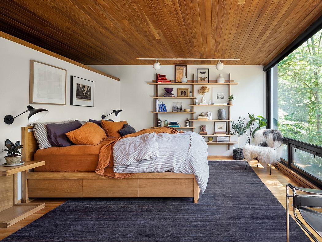 Cozy bedroom with wooden ceiling, built-in shelves, and large windows overlooking nature.