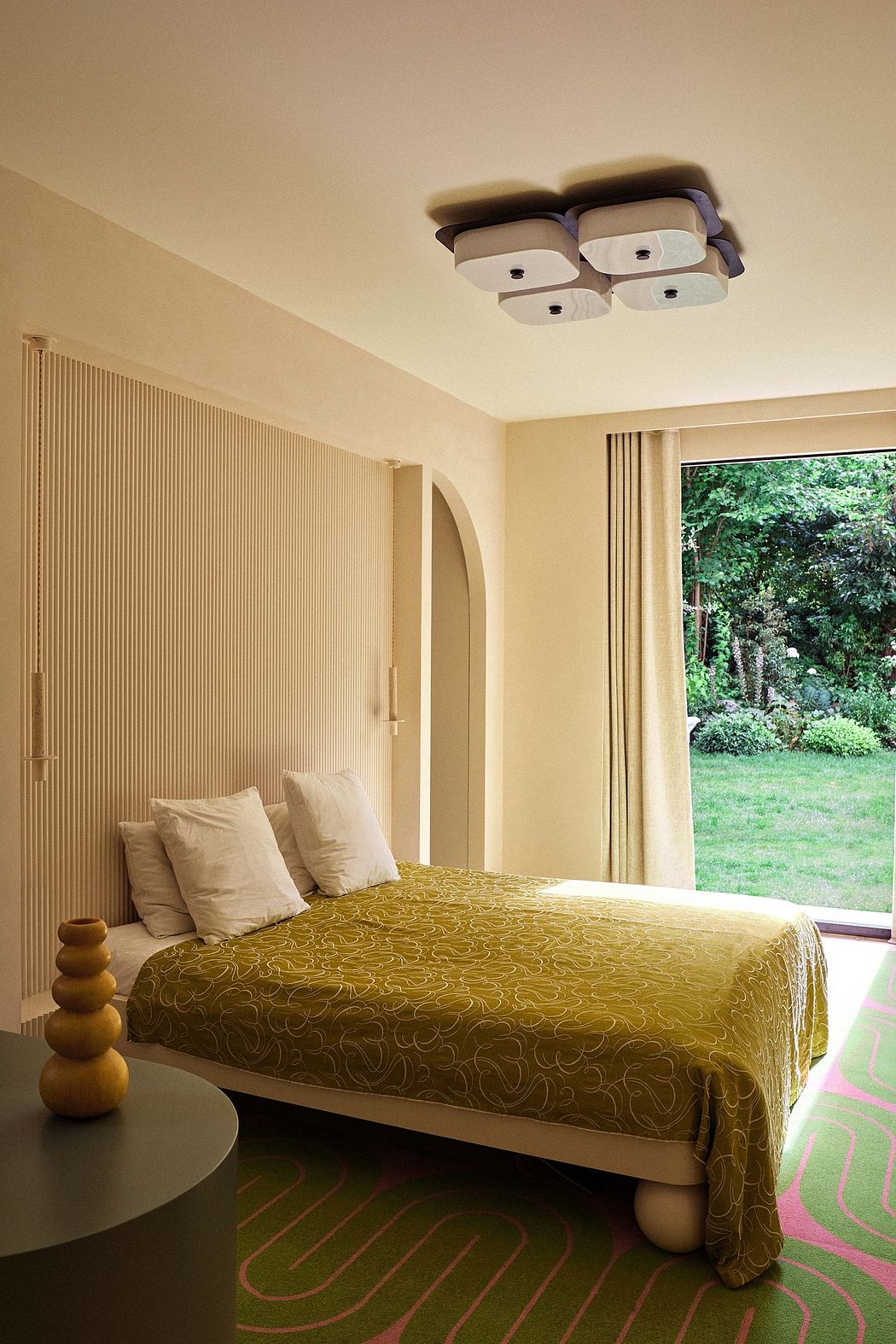 A cozy bedroom with a patterned yellow quilt, arched doorway, and recessed lighting.