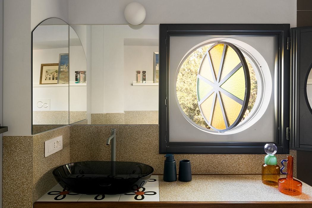 Bathroom with circular window, polished surfaces, and modern fixtures.