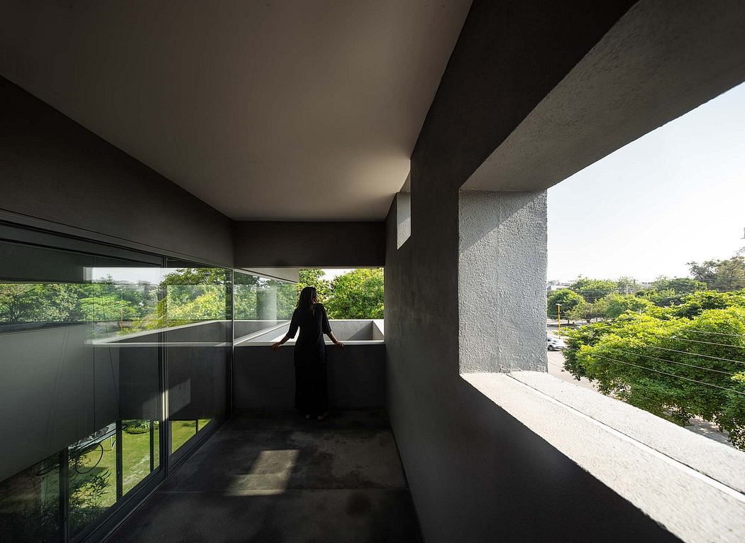 The image depicts a modern architectural design featuring expansive glass walls, a balcony, and a lush, green landscape visible from the interior.