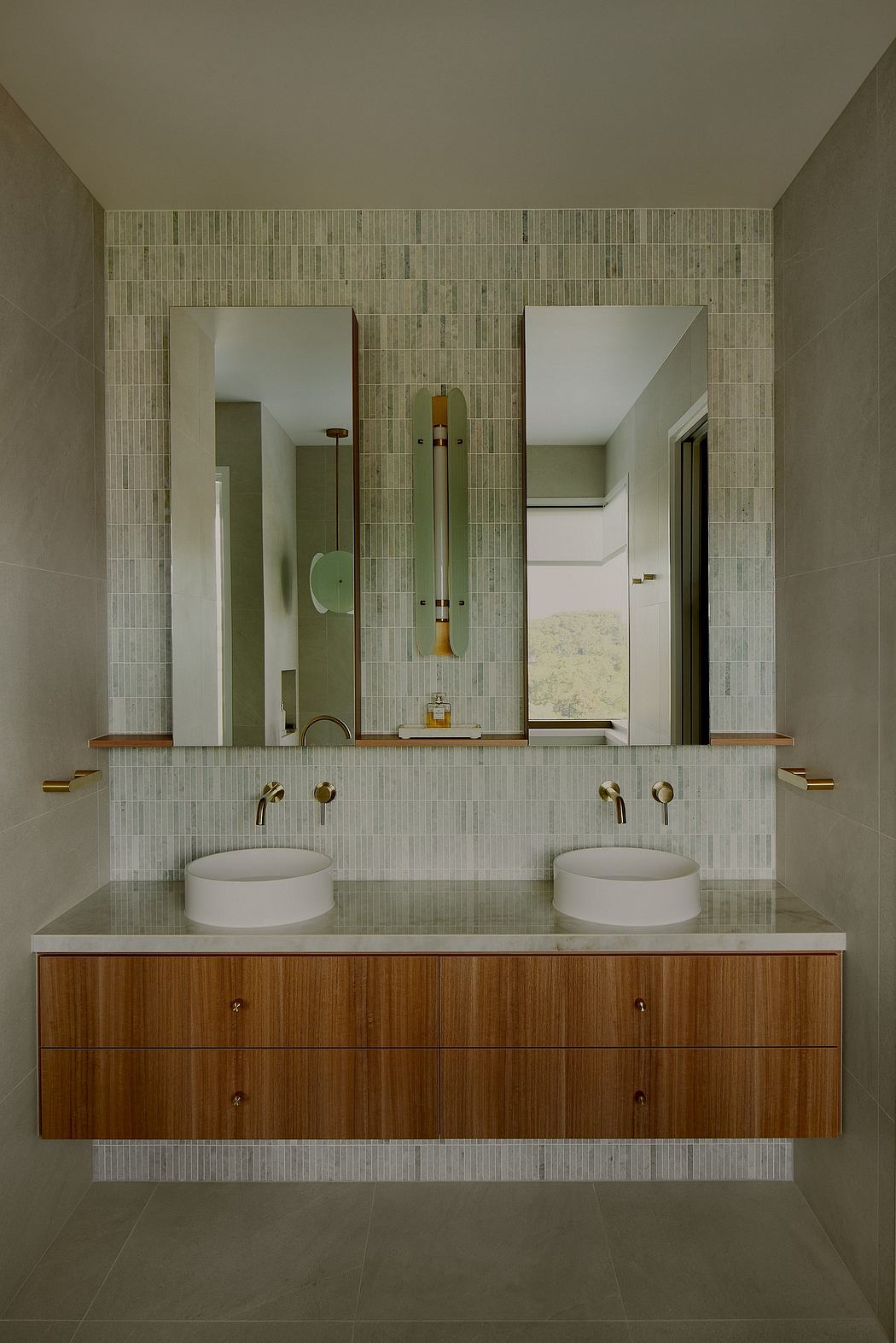 A modern bathroom with white tiled walls, wood vanity, and brass fixtures.