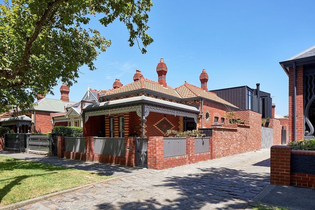 A striking brick building with intricate architectural details and decorative chimneys.