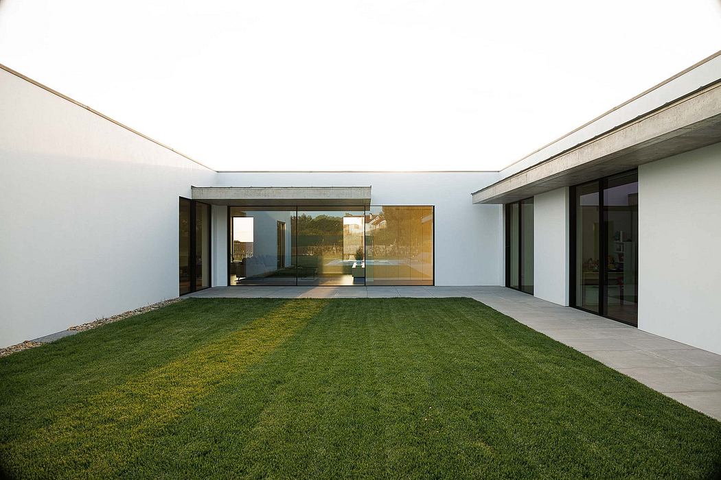 Modern minimalist architecture with a spacious, open-plan layout and a manicured lawn.