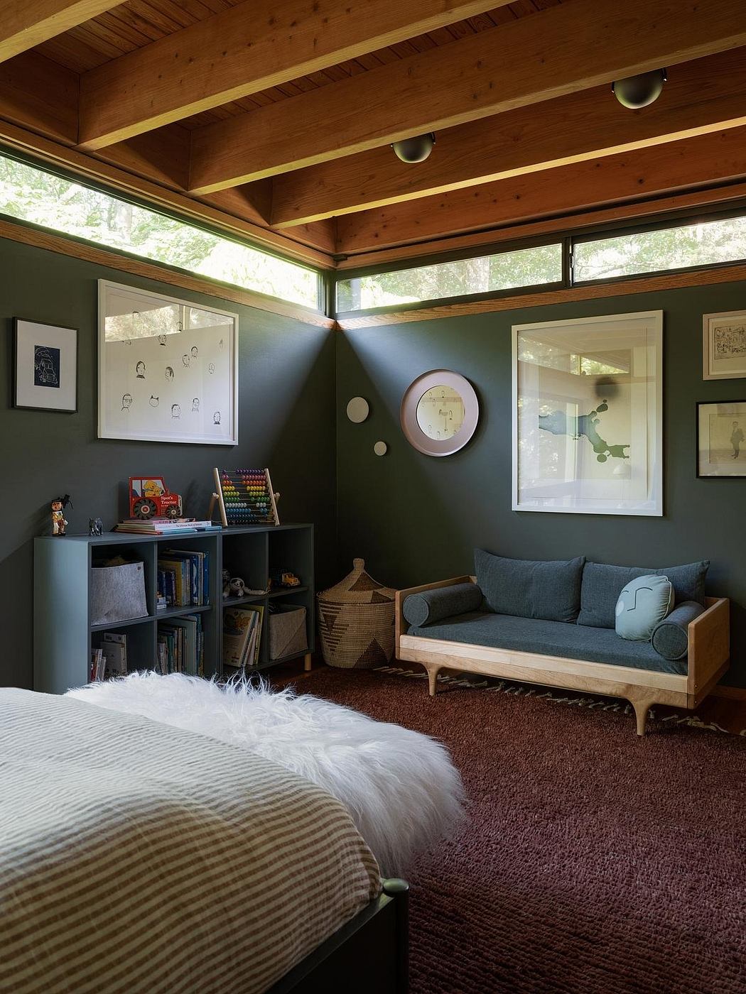 Cozy wood-paneled ceiling, built-in shelving, plush seating, and natural lighting create a warm, inviting space.