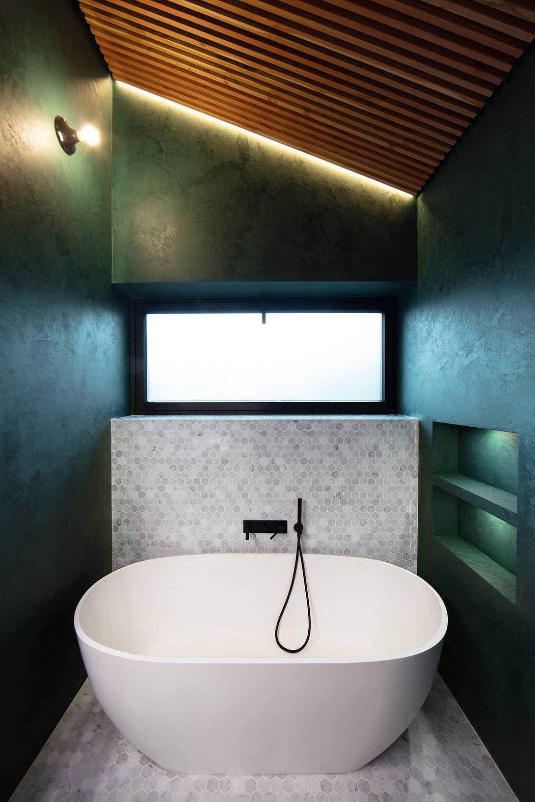 Minimalist bathroom with a freestanding bathtub, hexagonal tile flooring, and recessed lighting.