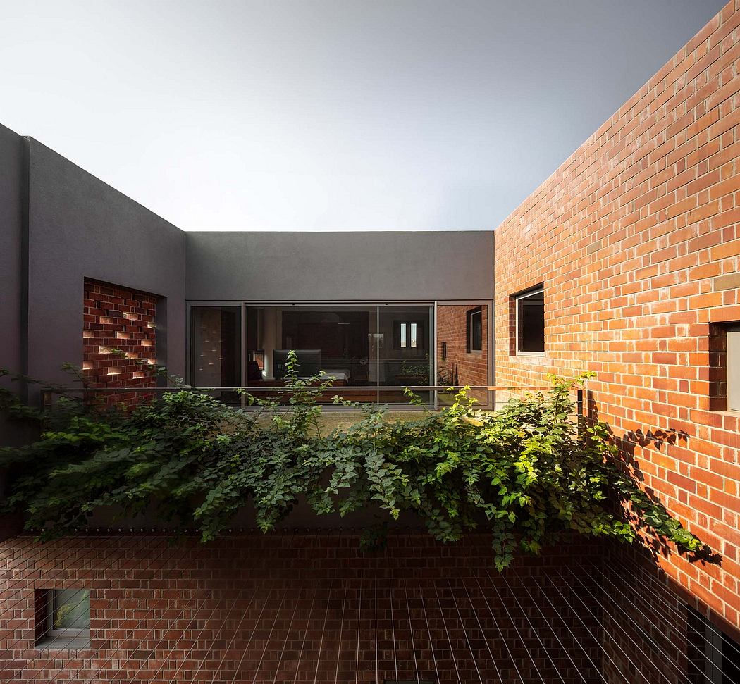 Striking brick facade contrasts with lush, verdant greenery surrounding the patio.