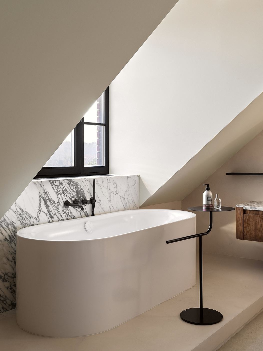 Sleek modern bathroom with freestanding tub, marble accent wall, and black fixtures.