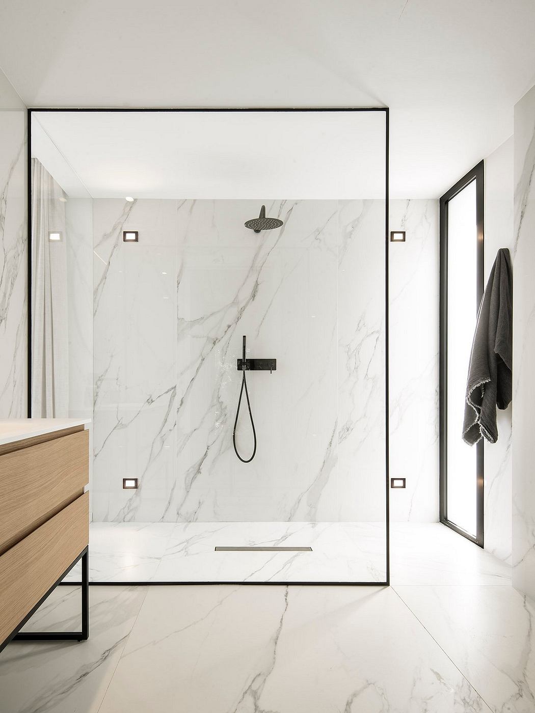 A modern bathroom with sleek, minimalist design featuring a large marble-like tile wall.