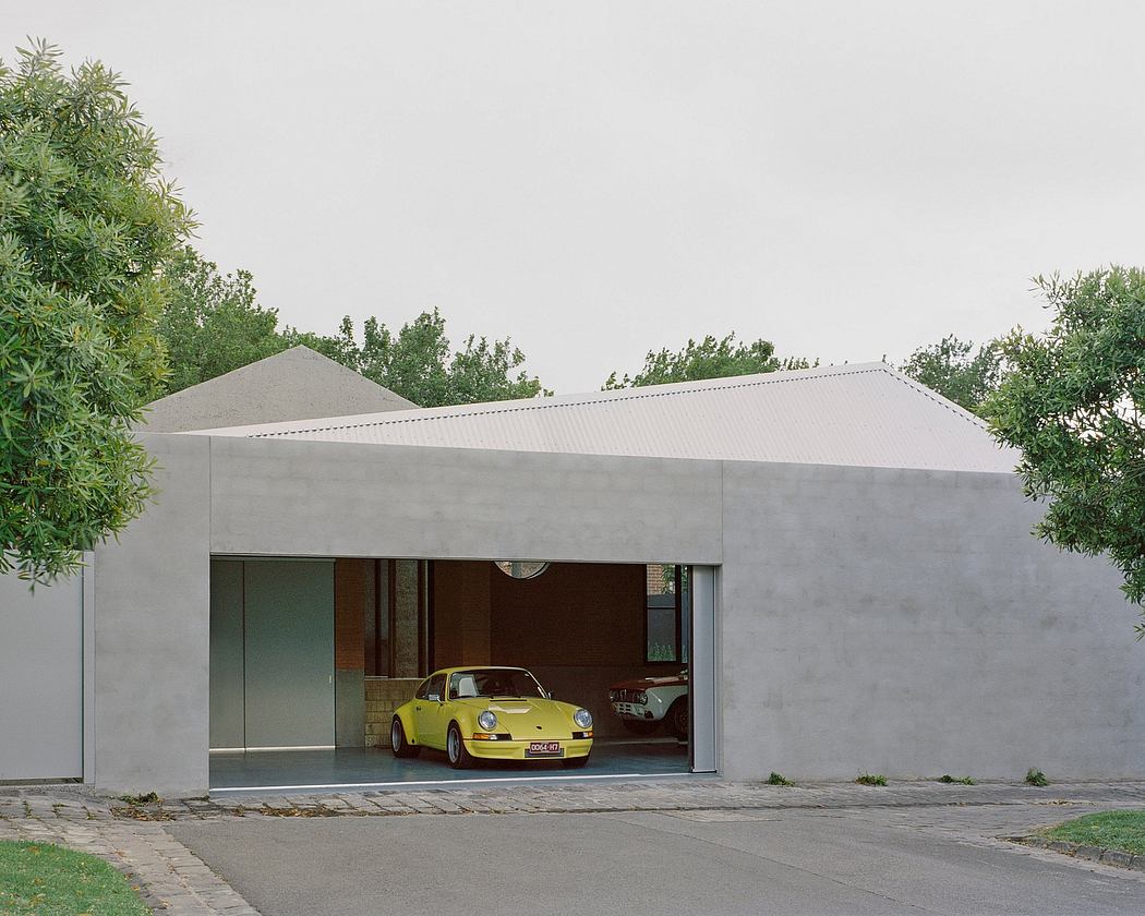 A modern, minimalist garage structure with a yellow sports car parked inside.
