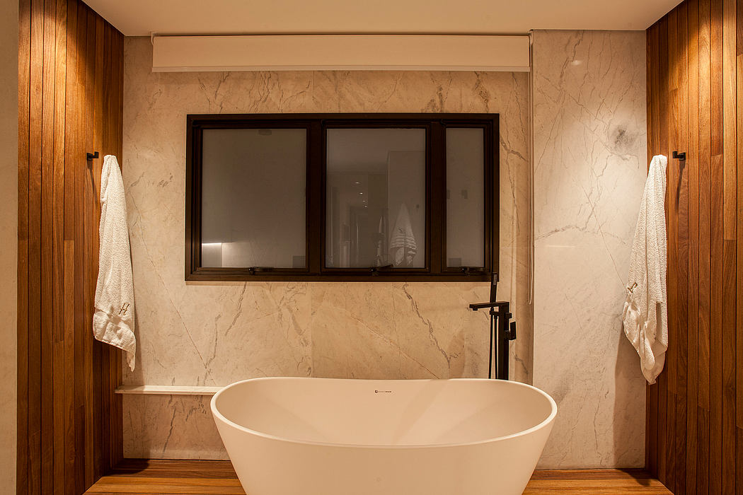 Modern bathroom with freestanding tub, marble walls, and wooden accents in a luxurious design.