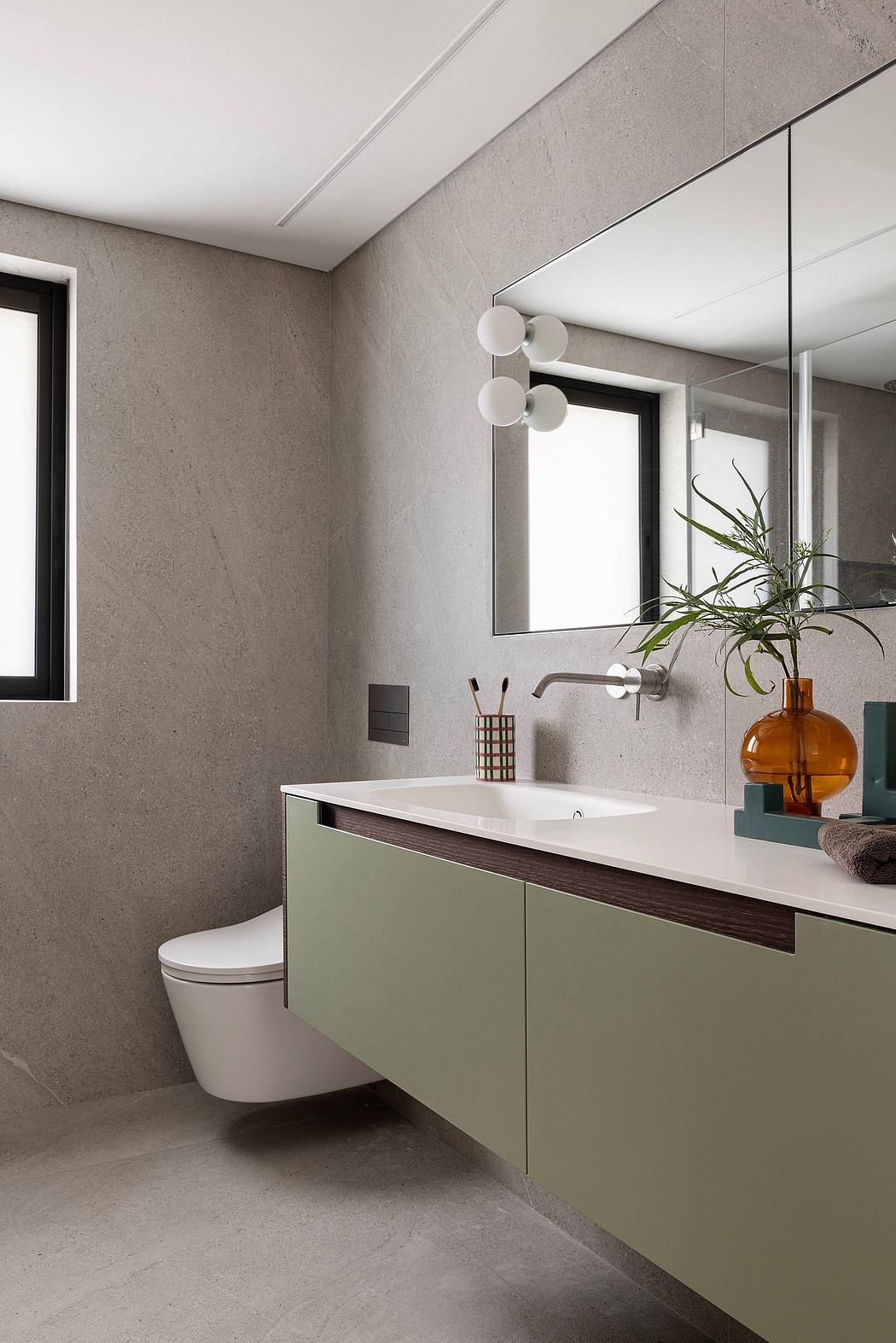 Modern bathroom with minimalist vanity, neutral color palette, and statement lighting.