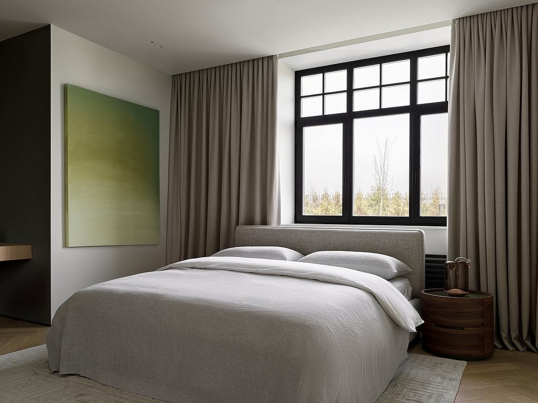 Spacious bedroom with floor-to-ceiling windows, modern gray upholstered bed, and minimalist decor.