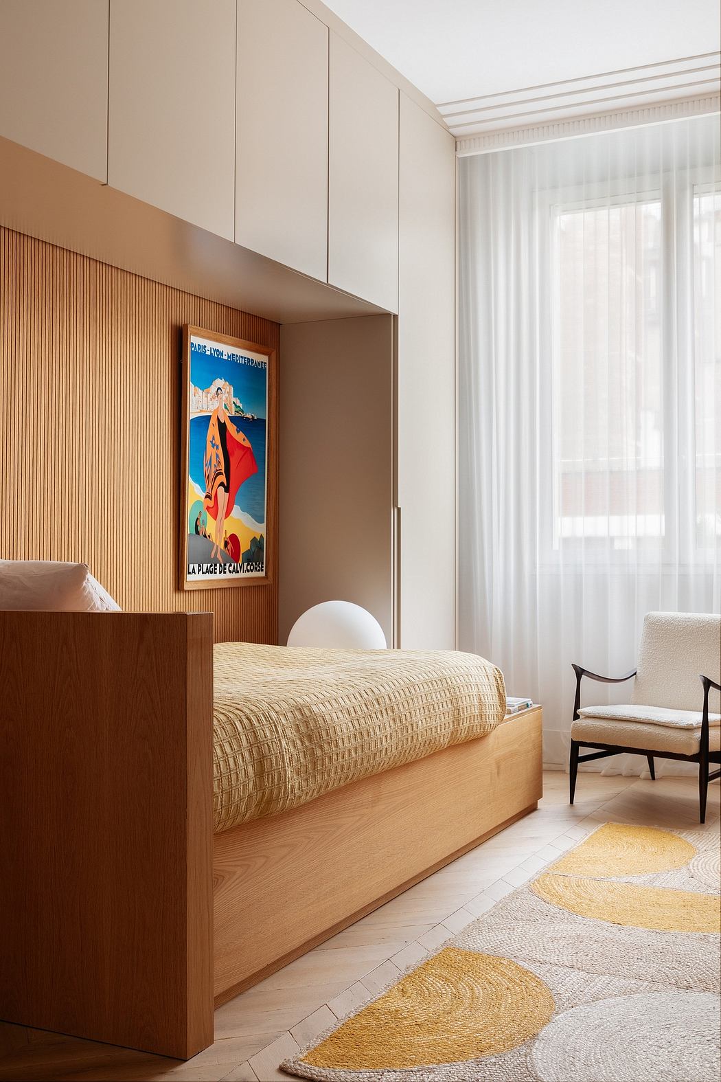 Minimalist bedroom with warm wood tones, built-in cabinetry, and a vibrant vintage poster.