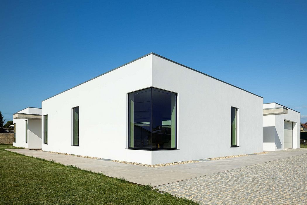 A modern, minimalist building with clean lines, large windows, and a flat roof.