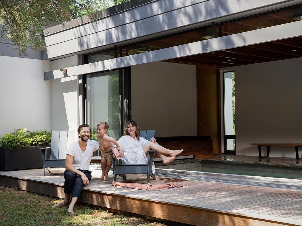 Modern, minimalist home with wood, glass, and concrete design elements. Tranquil outdoor seating area with pool.