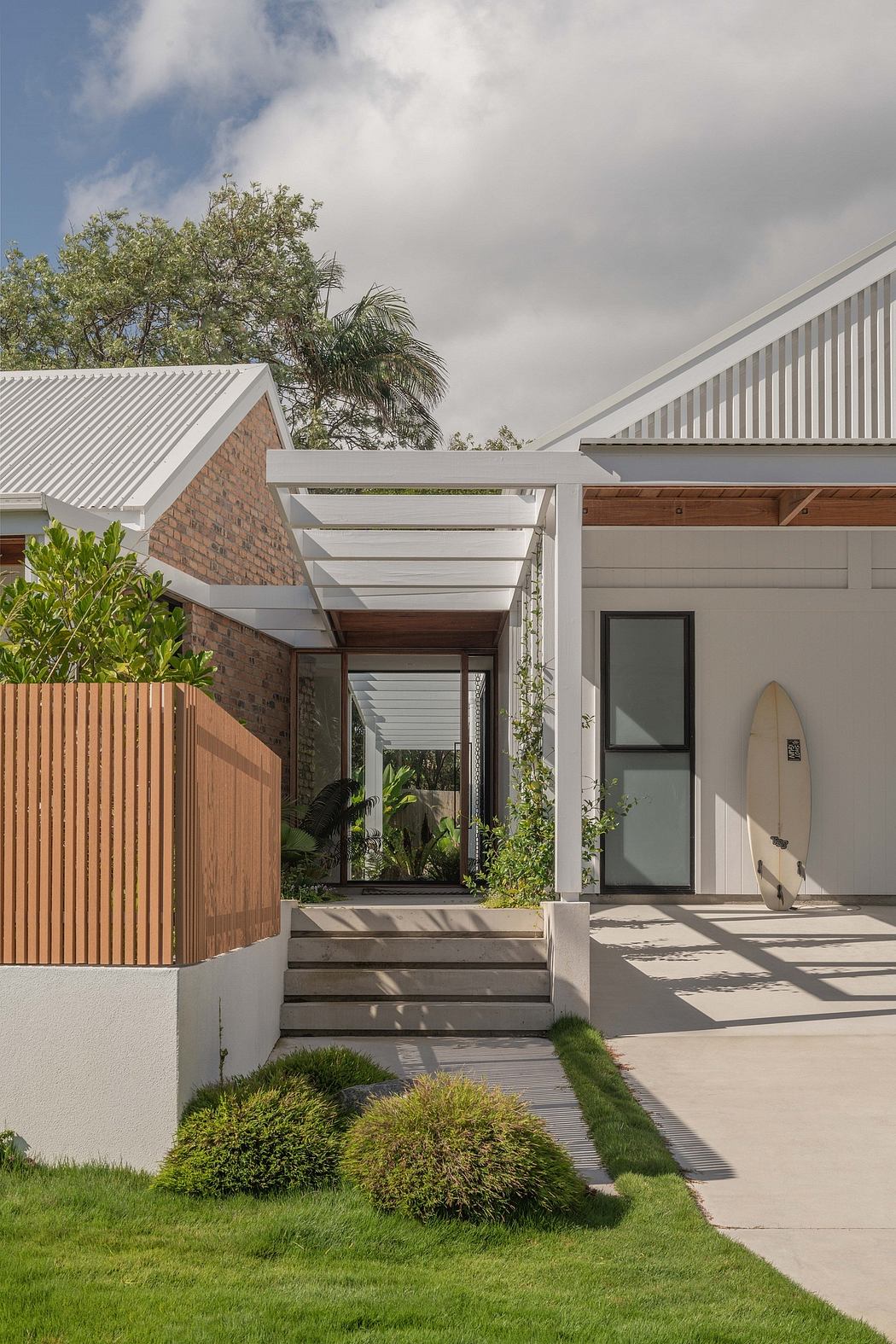 Contemporary home with modern architectural elements, including a covered entryway, brick walls, and a mix of wood and metal materials.
