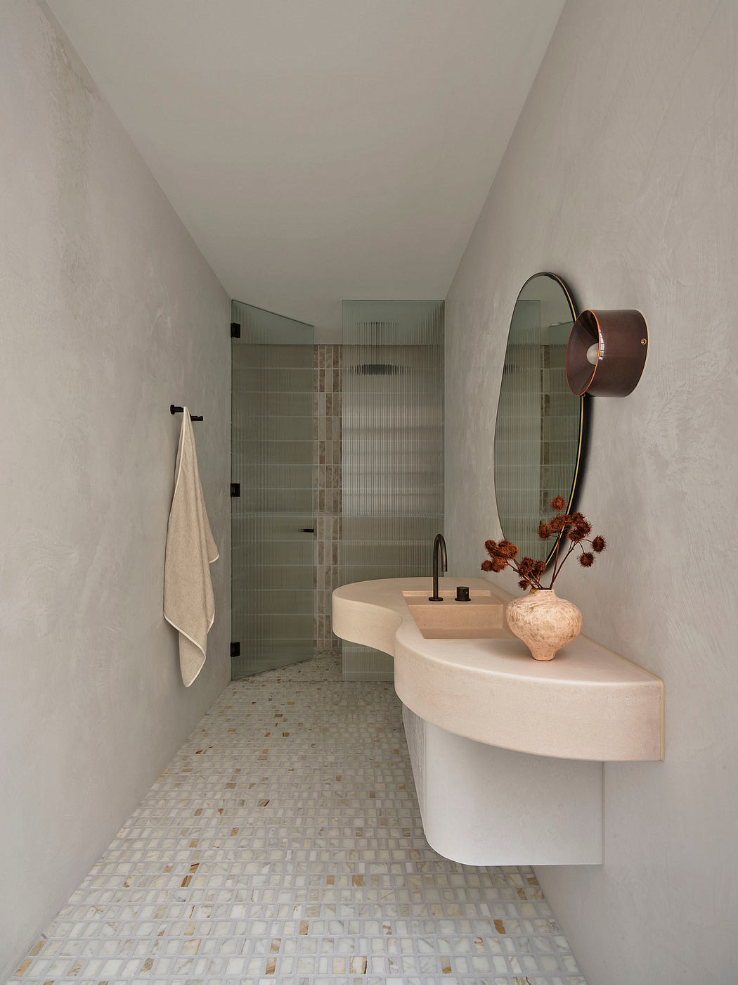 Sleek contemporary bathroom with recessed lighting, minimalist decor, and textured tile flooring.