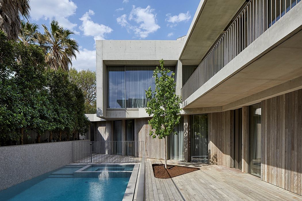 Modern minimalist architecture with concrete, wood, and glass elements surrounding a pool.