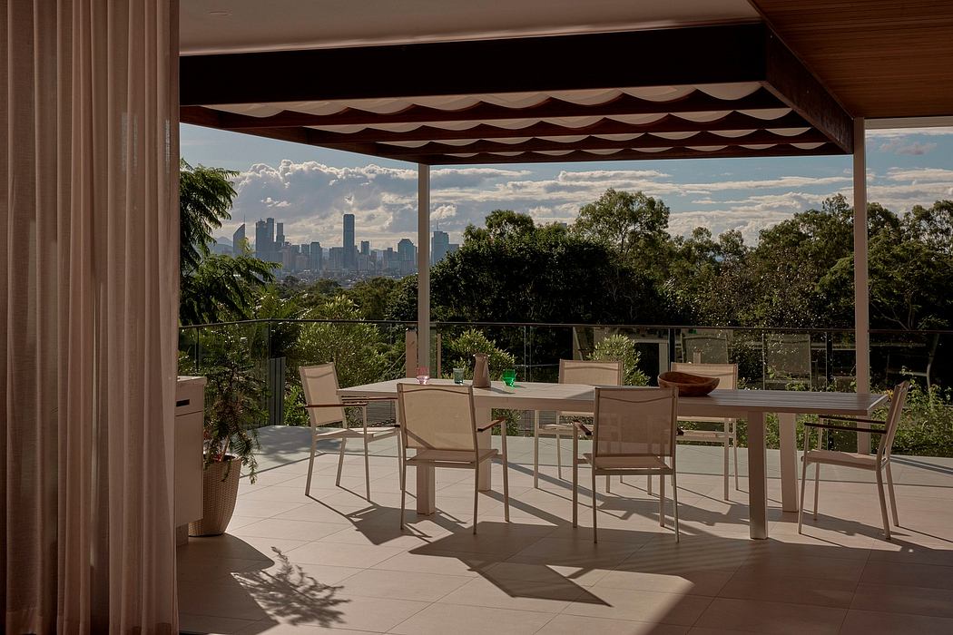Covered patio with a view of the city skyline, modern furniture, and lush greenery.
