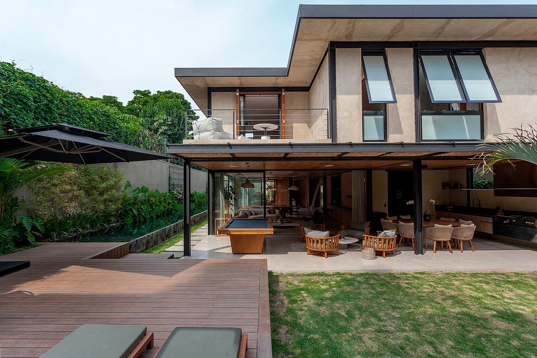 Contemporary home with open-plan design, wooden deck, and lush green surroundings.
