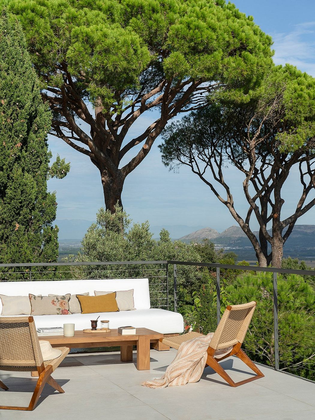 Cozy outdoor living area with wooden furniture, plush cushions, and sweeping mountain views.