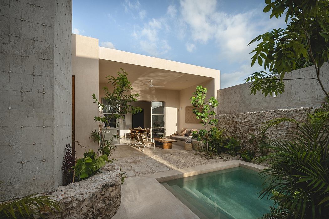 A modern, minimalist home with a small pool and lush foliage surrounding the outdoor living area.
