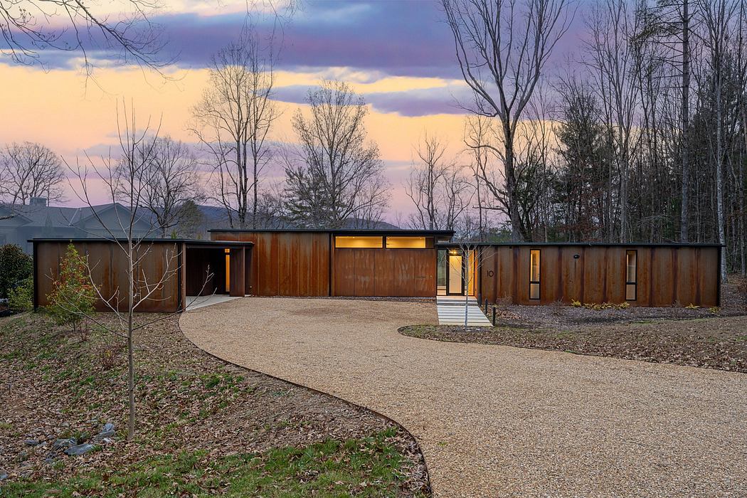 Sleek, modern home with wood and glass exterior, surrounded by nature's beauty.