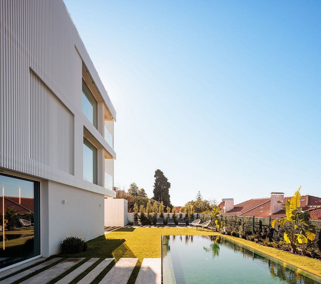 Exterior of a modern, sleek building with a reflecting pool and landscaped garden.