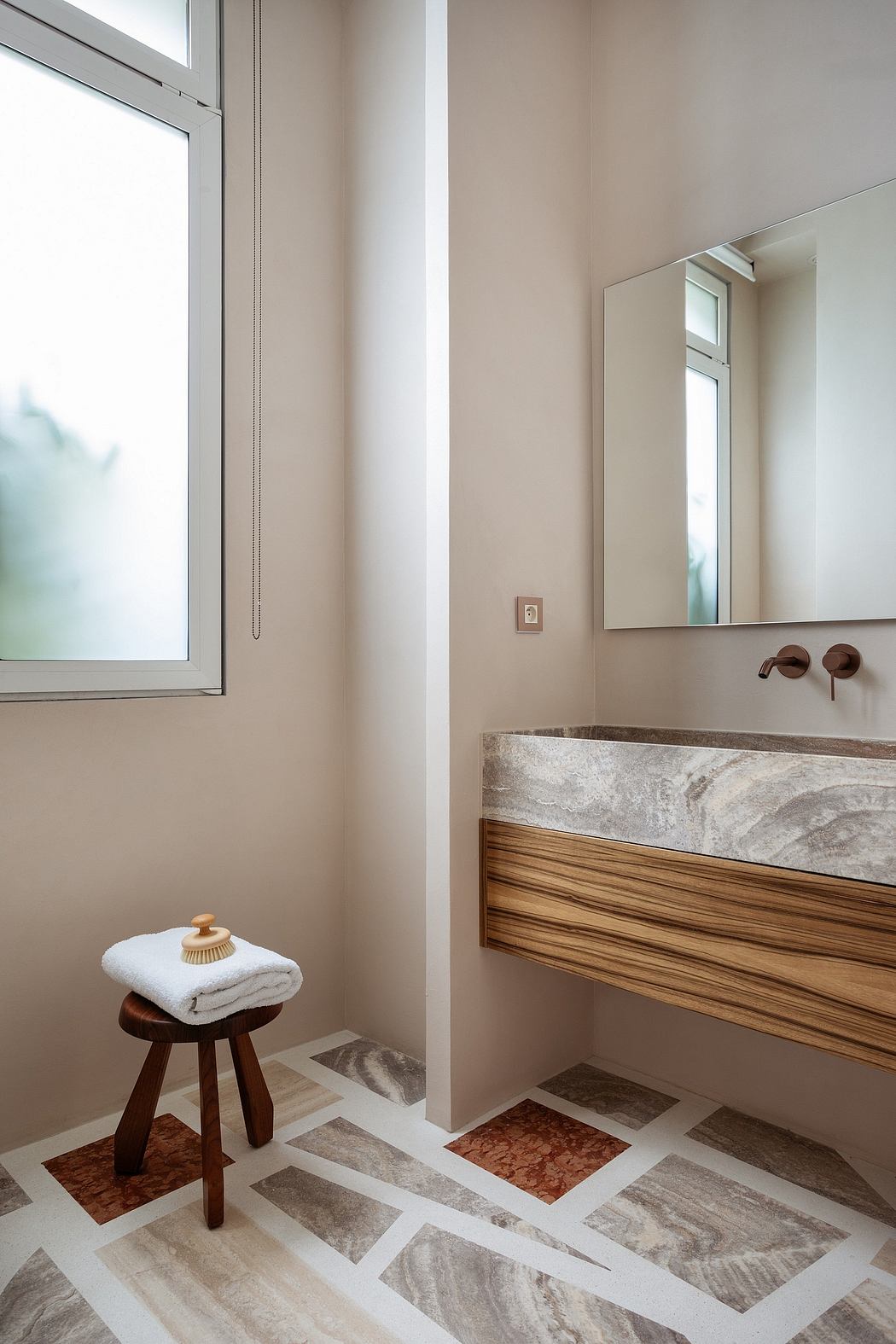 Elegant bathroom with wood vanity, marble countertop, and patterned tiled floor.