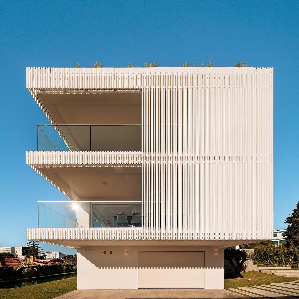 A modern, minimalist building with a striking white facade and intricate vertical lines.