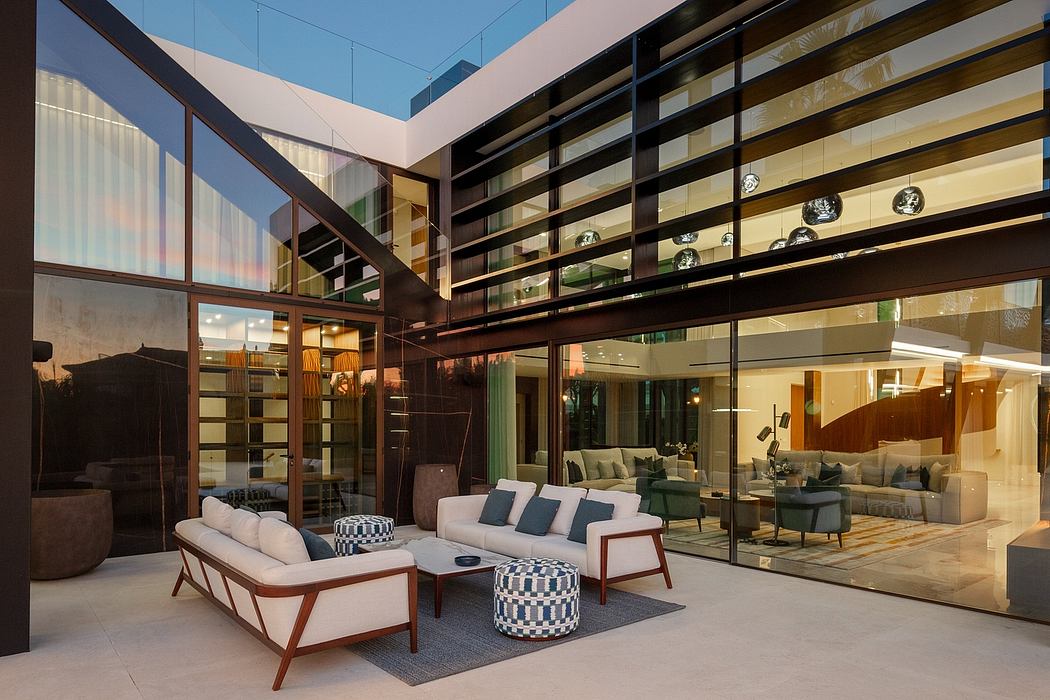 A modernist living space with floor-to-ceiling windows, stylish furniture, and decorative lighting.