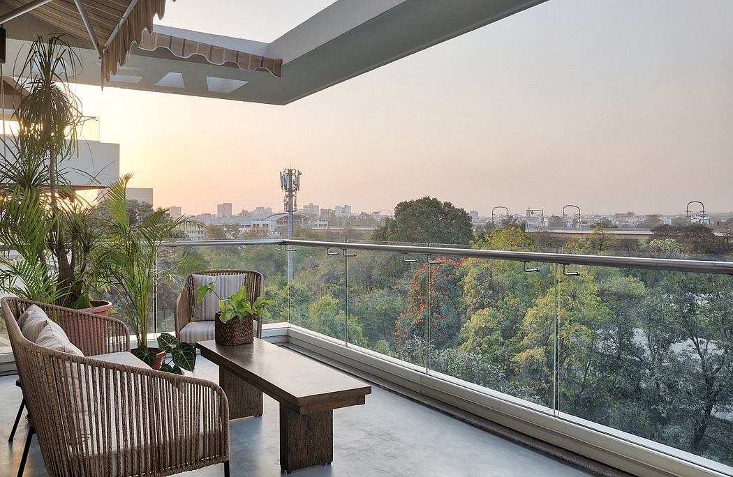 A modern balcony with glass railing, wooden furniture, and a picturesque cityscape view.