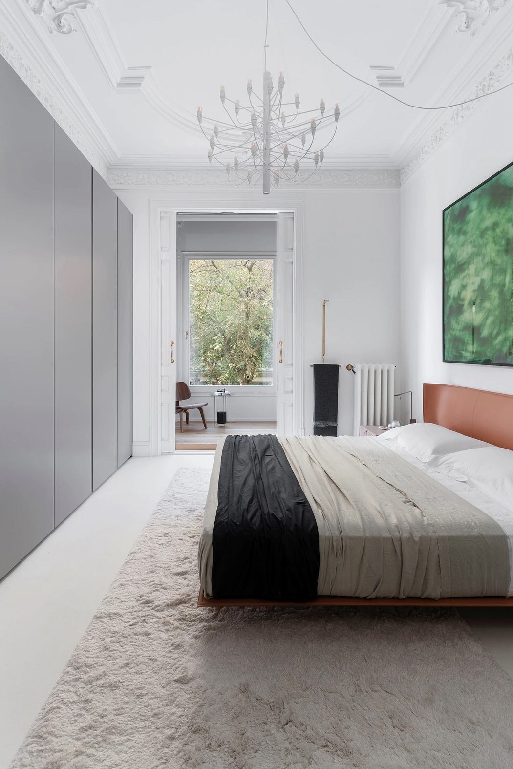 Ornate ceiling, modern furniture, and expansive window with lush outdoor view.