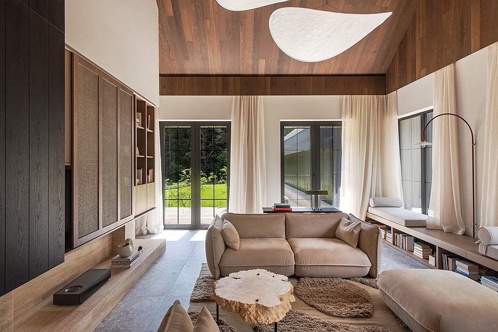 Spacious open-plan living area with high ceilings, wood paneling, and ample natural light.