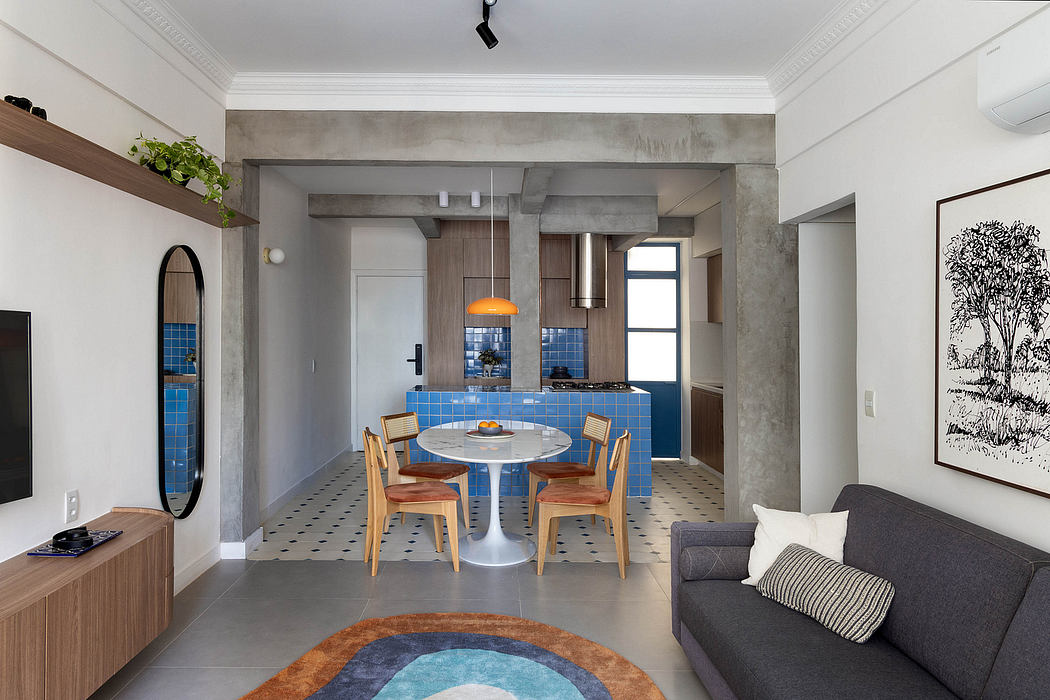 Modern apartment with open concept layout, concrete walls, and patterned tile flooring. Dining area with round table and wooden chairs.